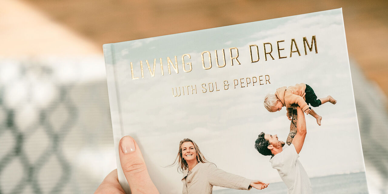 Photo book cover with gold lettering "Living our dream with Sol & Pepper"