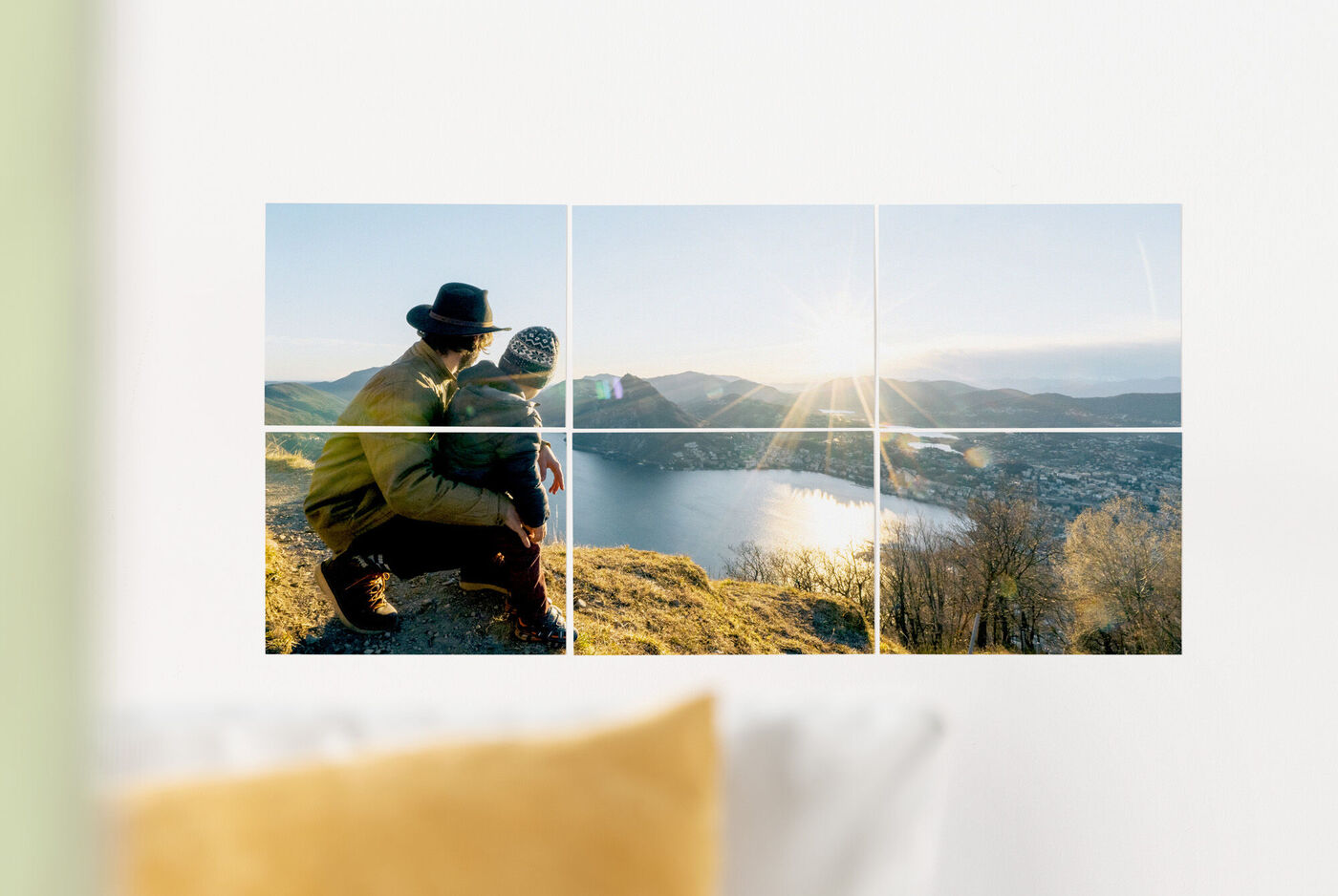 Two people sitting on a mountain enjoying the view of a lake at sunset