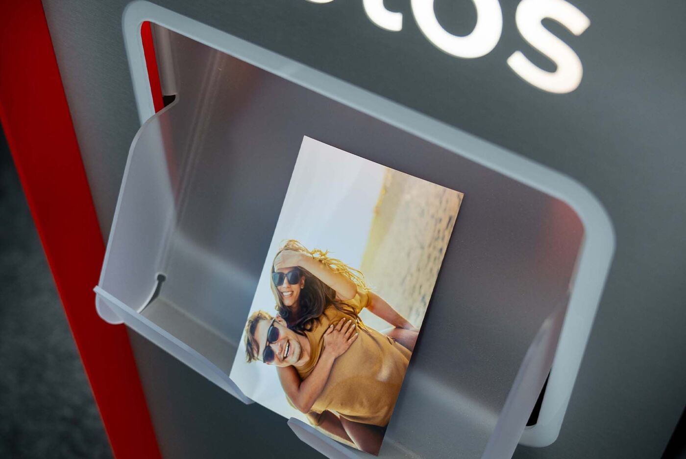 A photo is taken from a photo printer, with cheerful people on the beach.