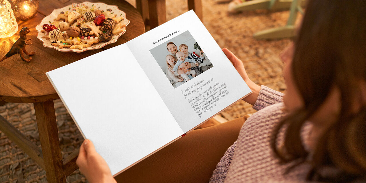 An open CEWE PHOTOBOOK shows a family picture and handwritten text.